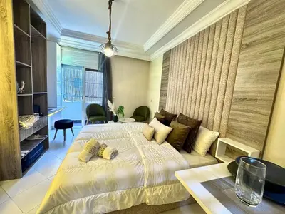 a bedroom with a large bed and a table and chairs at cosy studio au cœur de rabat agdal in Rabat