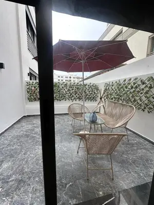 a patio with two chairs and a table with an umbrella at Résidence Signature Leving in Maarif