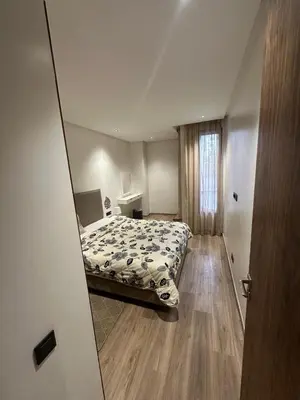 a bedroom with a bed and a mirror at Résidence Signature Leving in Maarif