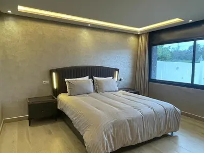a bedroom with a large bed with a large window at Charming Villa in Harhoura in Temara