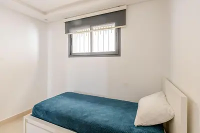 a bedroom with a bed with a blue blanket at Charming Villa in Harhoura in Temara