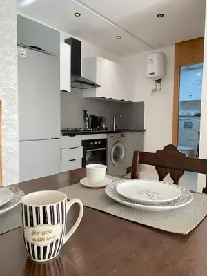 a kitchen with a wooden table with two mugs on it at Appartement in Casablanca