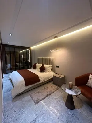 a bedroom with a large bed and a couch at Deux studios luxueux à palmiers Casablanca in Casablanca