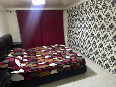 a bed in a room with a purple curtain at Maison in Mohammedia