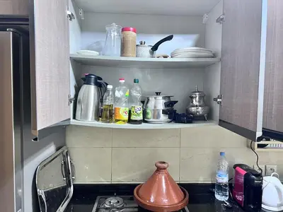 a kitchen with bottles and dishes on a shelf at Beachfront apartment in Rabat