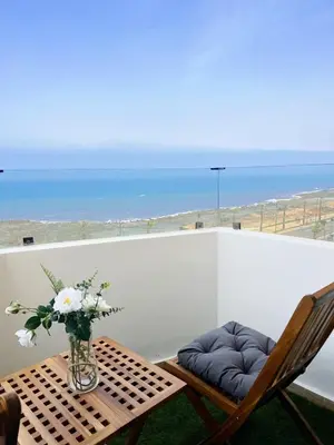 a table and chairs with a vase of flowers on a balcony at Ocean view & sunset in the heart of Rabat 2 in Rabat