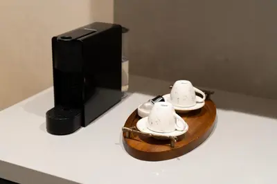 two tea cups on a wooden tray next to a microwave at Prime location unmatched comfort in Casablanca