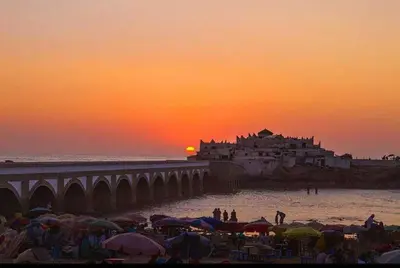 a group of people standing on the beach at sunset at Bienvenue à Casablanca centre idéal pro ou famille in Casablanca