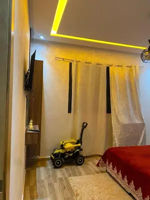 a yellow baby stroller sitting in a bedroom at Appartement meublé a sidi rahal in Sidi Rahal