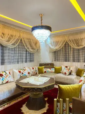 a living room with a couch and a chandelier at Appartement meublé a sidi rahal in Sidi Rahal
