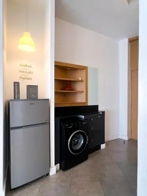 a laundry room with a refrigerator and a washing machine at appartement Gautier in Casablanca