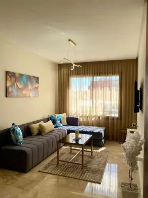 a living room with a couch and a table at Très beau appartement a tadart au centre de casablanca in Casablanca