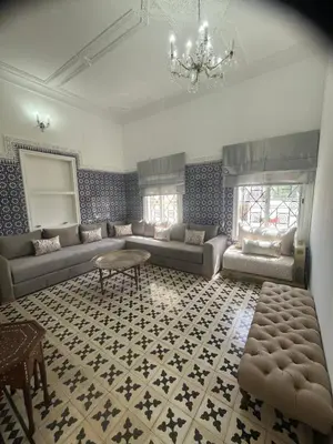 a living room with couches and a chandelier at Maison traditionnelle spacieuse in Rabat