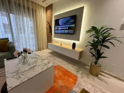 a living room with a tv on a wall at Escale Confortable pour un Séjour Inoubliable in Maarif