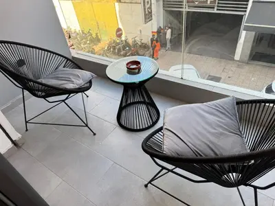 a patio with two chairs and a table and a window at Escale Confortable pour un Séjour Inoubliable in Maarif
