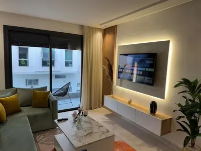 a living room with a couch and a flat screen tv at Escale Confortable pour un Séjour Inoubliable in Maarif
