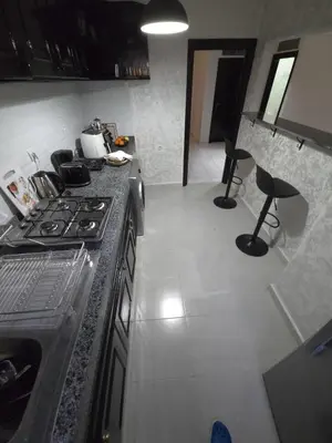 a kitchen with a stove and two chairs in it at Faridi house in Casablanca