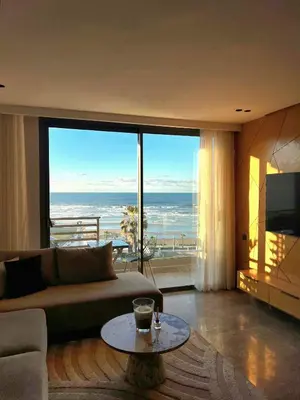 a living room with a couch and a view of the ocean at Panoramic ocean view appartement in Casablanca