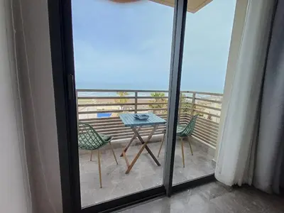 a table and chairs on a balcony with a view of the ocean at Panoramic ocean view appartement in Casablanca