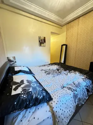 a bedroom with a bed with a blue comforter at Jardin mohammedia in Mohammedia