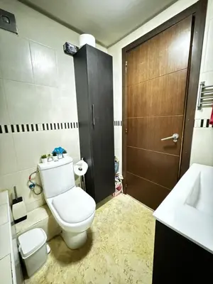 a bathroom with a toilet and a sink and a door at Jardin mohammedia in Mohammedia
