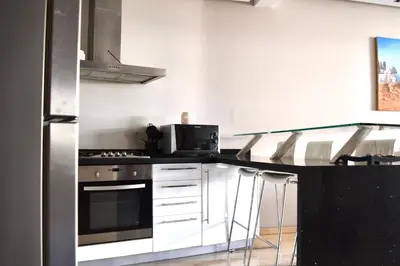a kitchen with a counter with a stove and a microwave at Appartement Sacré-Cœur in Casablanca