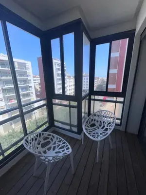 two chairs and tables on a balcony with windows at Anfa Casablanca in Casablanca