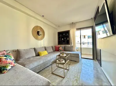 a living room with a couch and a table at Kawtar in Mansouria