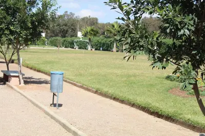 a blue trash can sitting next to a park at Your comfortable stopover in Nouaseur