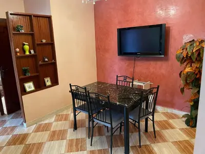a dining room with a table and a flat screen tv at Dar dyafa in Casablanca
