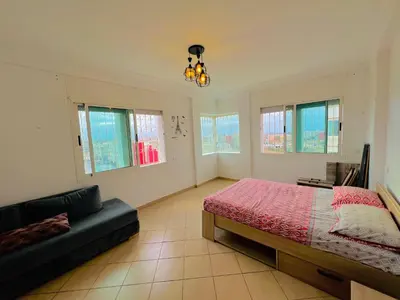 a bedroom with a bed and a couch in it at Apparemment à louer au centre ville Bouznika in Bouznika