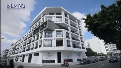 a white building with a person on a bike in front at Modern apartment in Casablanca in Casablanca