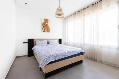 a bedroom with a bed in a white room at Beach Vibe Villa - Sunny Stay in O Ben Slimane
