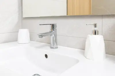 a bathroom sink with a faucet and two paper towels at Beach Vibe Villa - Sunny Stay in O Ben Slimane