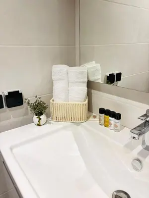 a bathroom with a sink with a basket of towels at Beautiful spacious apartment in Casablanca in Casablanca