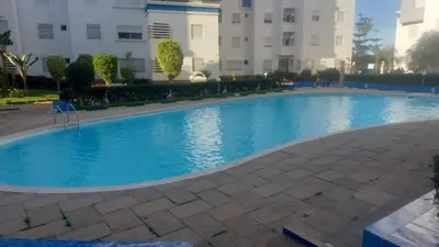 a large blue swimming pool in front of a building at La passage inoubliable F in Bouznika