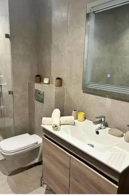 a bathroom with a sink and a toilet and a mirror at Résidence fal green bouskoura in Bouskoura