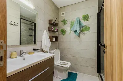 a bathroom with a sink and a toilet and a mirror at Appartement au parc à 3 minutes de la plage in Mohammedia