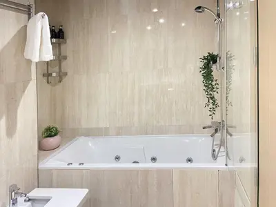 a white bath tub in a bathroom with a sink at Cozy Boho 2BR Prestigia Stadium View in Rabat