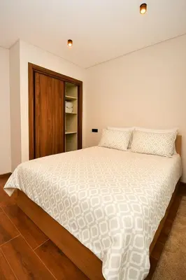 a bedroom with a large white bed with wooden floors at Atelier Aedes - Studio 2 in Maarif