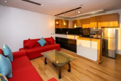 a living room with a red couch and a kitchen at 1BR - Casa Voyageurs - Belvedere in Maarif