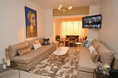 a living room with a couch and a flat screen tv at Abdelmoumen Central Spacious Haven in Maarif