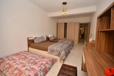 a hotel room with two beds and a couch at Abdelmoumen Central Spacious Haven in Maarif