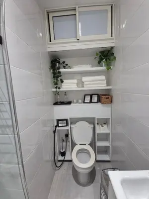a white bathroom with a toilet and a sink at Studio close to Descartes high school in Rabat