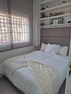 a white bed in a room with a window at Studio close to Descartes high school in Rabat