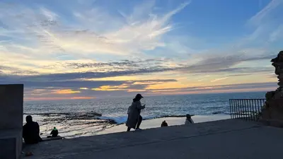 a group of people on the beach at sunset at SUITOUISS - Océan 2 - Panoramic Sea View in Downtown Rabat in Rabat