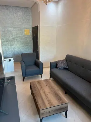 a living room with a couch and two chairs at Steps to the beach in Sidi Rahal