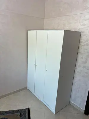 a white cabinet in the corner of a room at Steps to the beach in Sidi Rahal