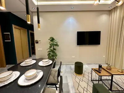 a dining room with a table and chairs and a tv at CosmoStay Airport Casablanca Appart in Nouaseur