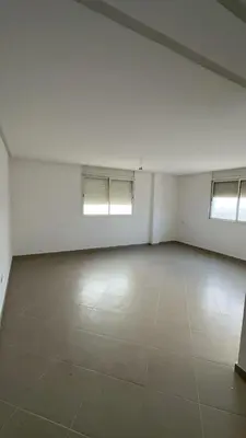 an empty room with white walls and two windows at dekra bouznika in Bouznika